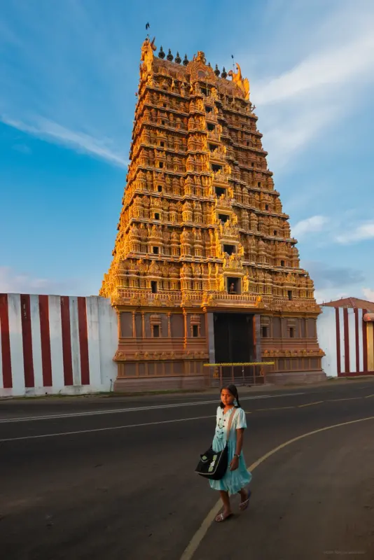 A girl in a light green dress walking in front of Nallur Kandaswamy Temple - Jaffna, Sri Lanka
