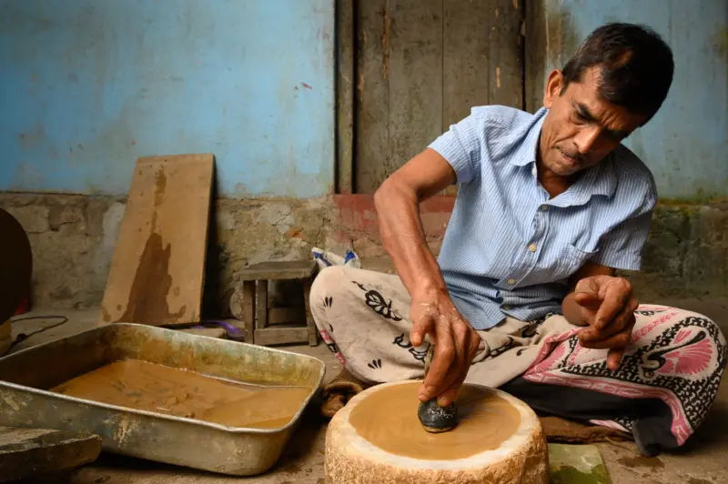 Last in the line of traditional eye glass makers, Chulamani Gedara Gunasoma Nawarathne, curving a quarts crystal into a lens - Pilimathalawa, Sri Lanka